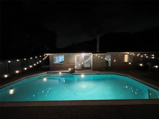 view of pool at twilight