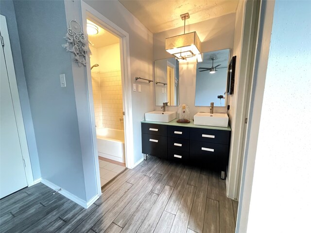 bathroom featuring vanity, ceiling fan, hardwood / wood-style flooring, and tiled shower / bath combo