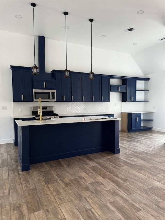 kitchen featuring decorative light fixtures, stainless steel appliances, light countertops, blue cabinetry, and open shelves