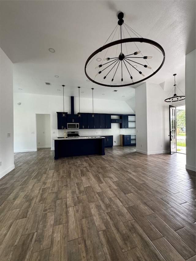 unfurnished living room featuring a textured ceiling, sink, dark hardwood / wood-style floors, and a notable chandelier