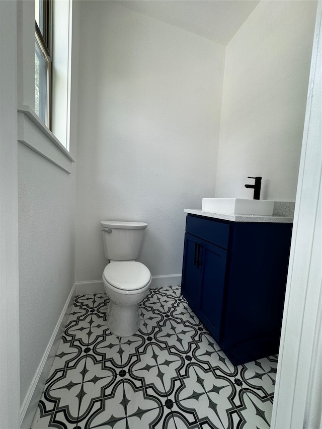 bathroom with tile patterned flooring, vanity, and toilet