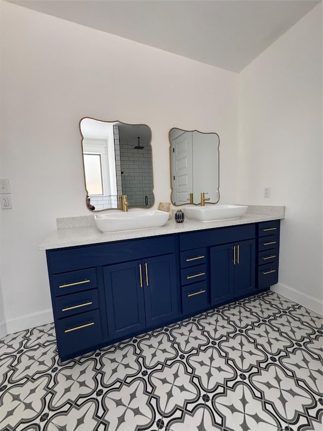 full bath featuring a stall shower, a sink, and baseboards