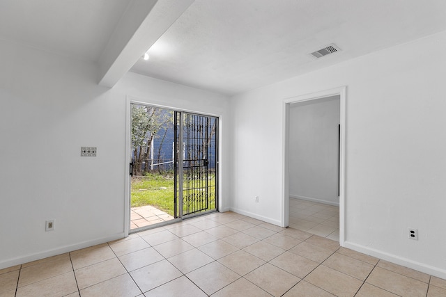 spare room with beam ceiling and light tile patterned floors