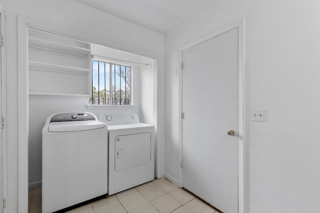 clothes washing area with washing machine and dryer and light tile patterned floors