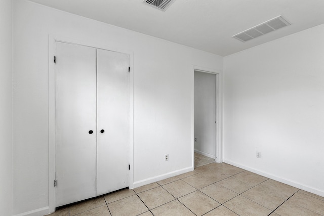 unfurnished bedroom with a closet and light tile patterned floors