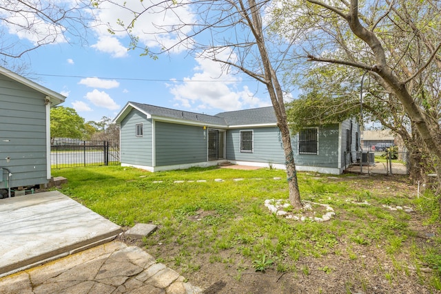 rear view of house with central AC, a yard, and a patio