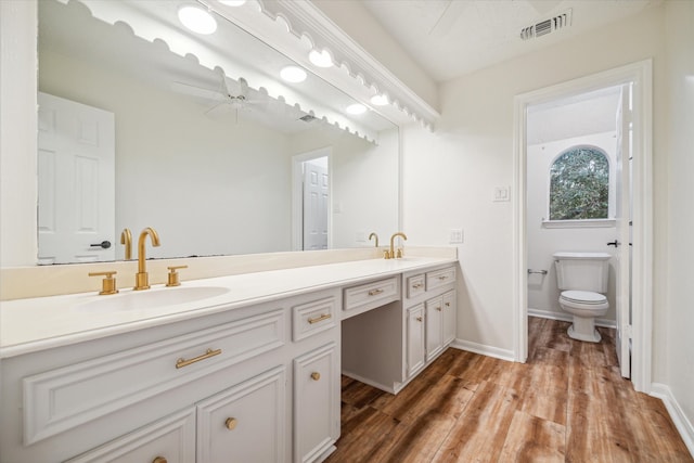 bathroom with vanity, toilet, ceiling fan, and hardwood / wood-style floors