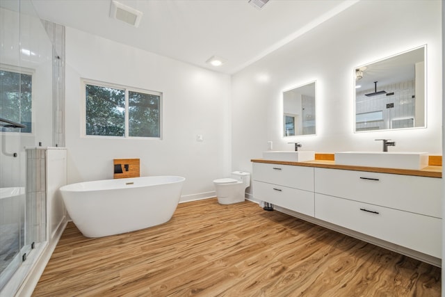 full bathroom with vanity, toilet, plus walk in shower, and wood-type flooring