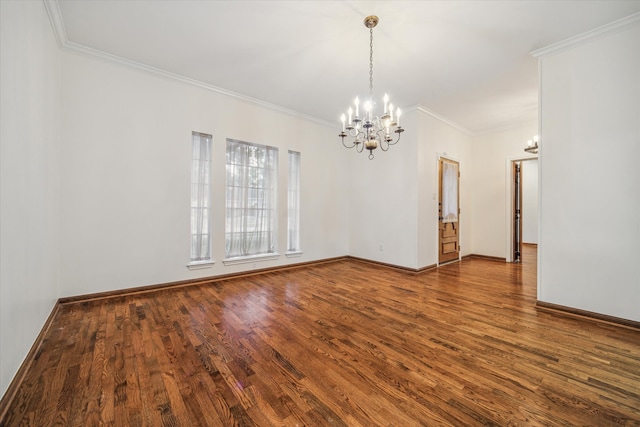 empty room featuring hardwood / wood-style flooring, ornamental molding, and a chandelier