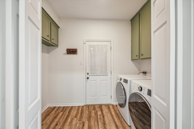 laundry area with washer and dryer, hardwood / wood-style flooring, a textured ceiling, and cabinets