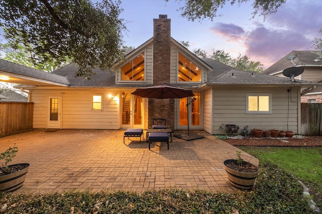 back house at dusk with a patio