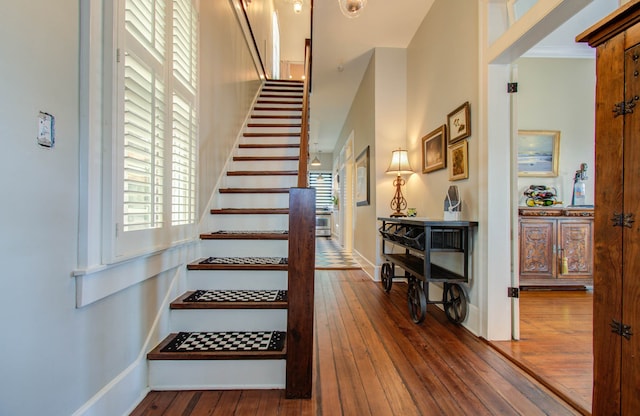 staircase with ornamental molding, hardwood / wood-style floors, and plenty of natural light