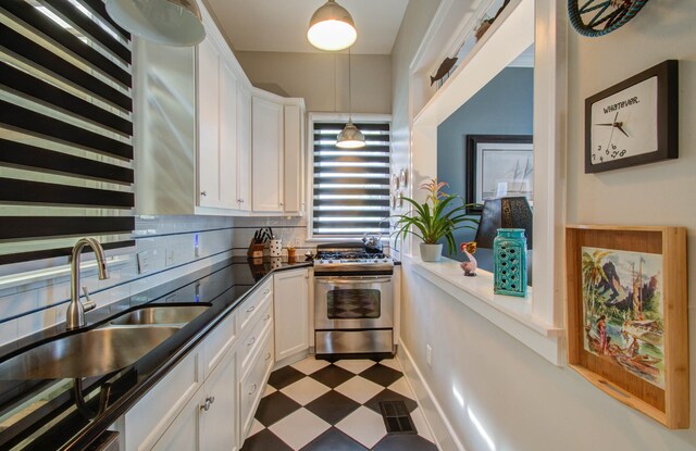 kitchen featuring white cabinetry, backsplash, stainless steel range oven, and sink