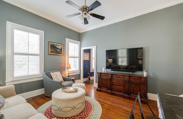 living room with crown molding, ceiling fan, and dark hardwood / wood-style flooring