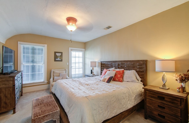 bedroom with vaulted ceiling, light colored carpet, and ceiling fan