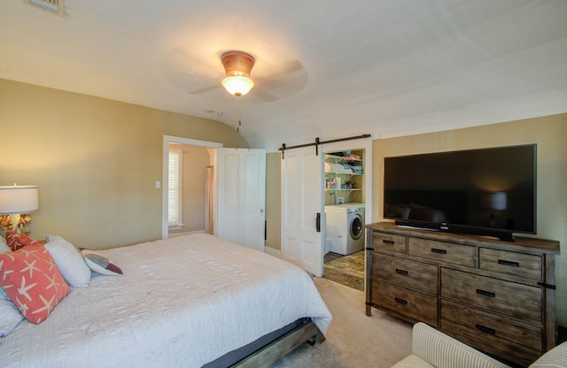 carpeted bedroom featuring ceiling fan, washing machine and dryer, lofted ceiling, and a barn door