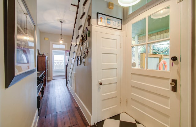 hallway with a wealth of natural light and dark hardwood / wood-style flooring