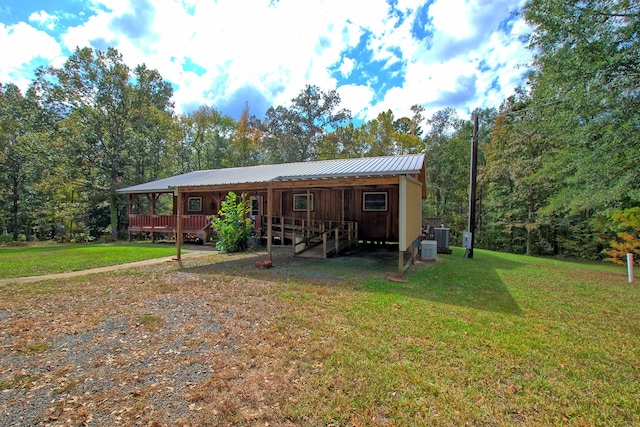 exterior space with a lawn, a porch, and central air condition unit