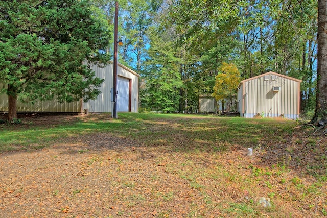 view of yard featuring a garage and an outbuilding