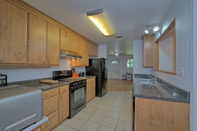 kitchen featuring sink, light tile patterned floors, black appliances, and a textured ceiling