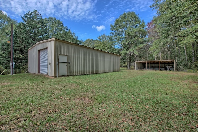 view of yard featuring a garage and an outbuilding