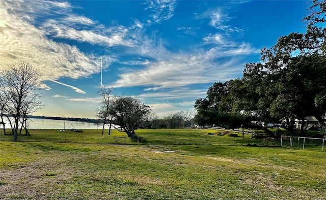 view of yard featuring fence and a water view