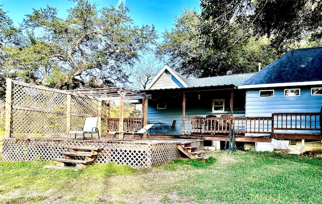 back of property with a wooden deck and a lawn