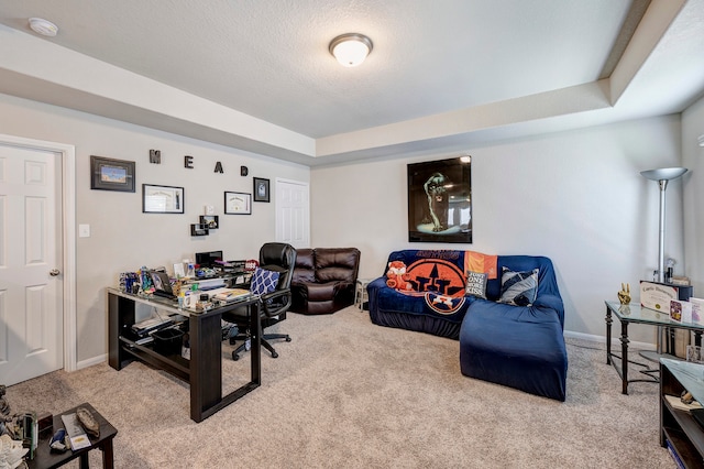 carpeted home office featuring a textured ceiling and a raised ceiling