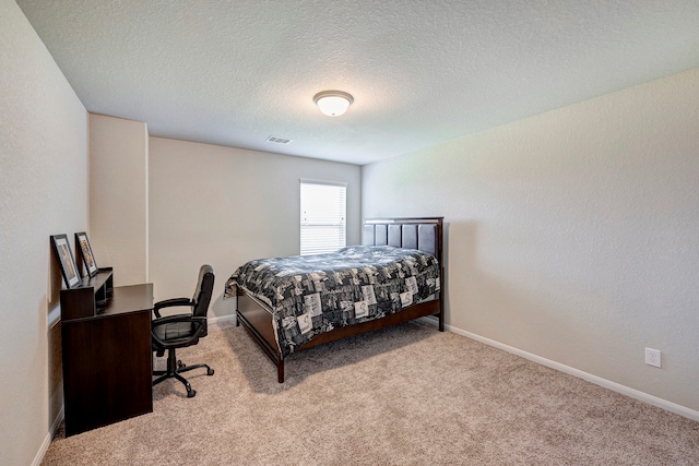 bedroom with light carpet and a textured ceiling