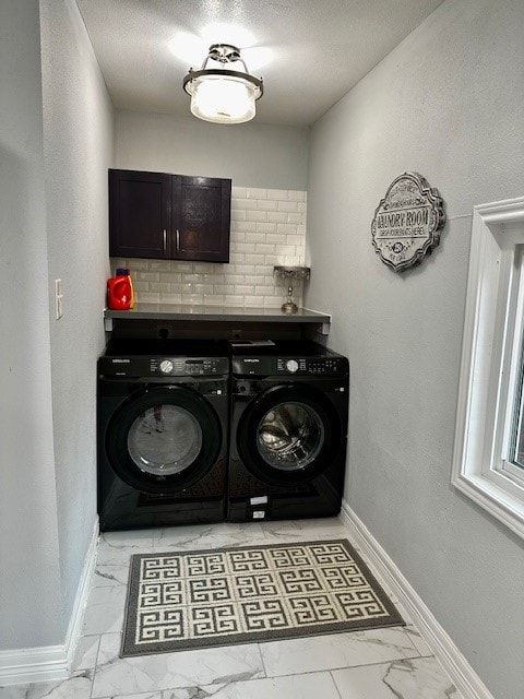 washroom featuring washing machine and dryer and cabinets