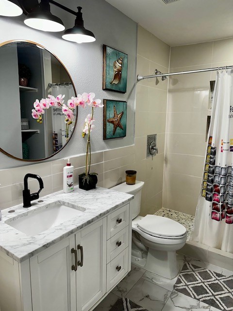 bathroom featuring vanity, toilet, and a shower with shower curtain