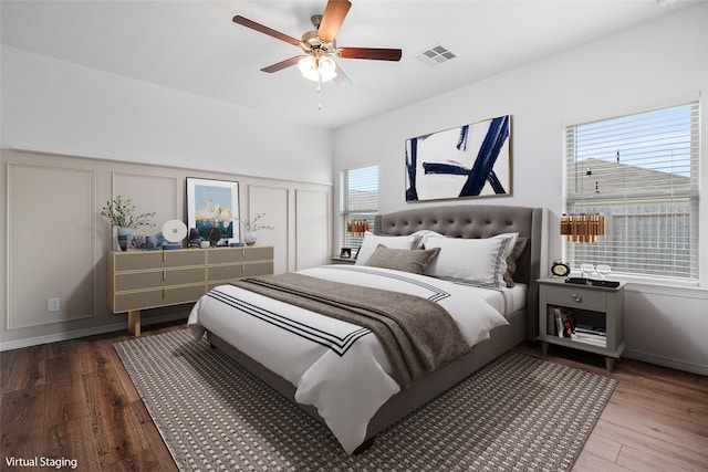 bedroom featuring multiple windows, hardwood / wood-style flooring, and ceiling fan