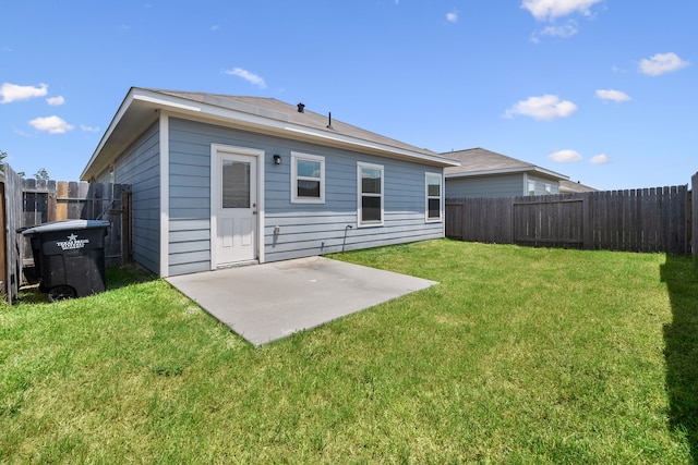 rear view of property featuring a yard and a patio area