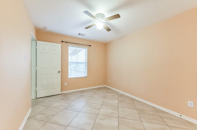 tiled empty room featuring ceiling fan