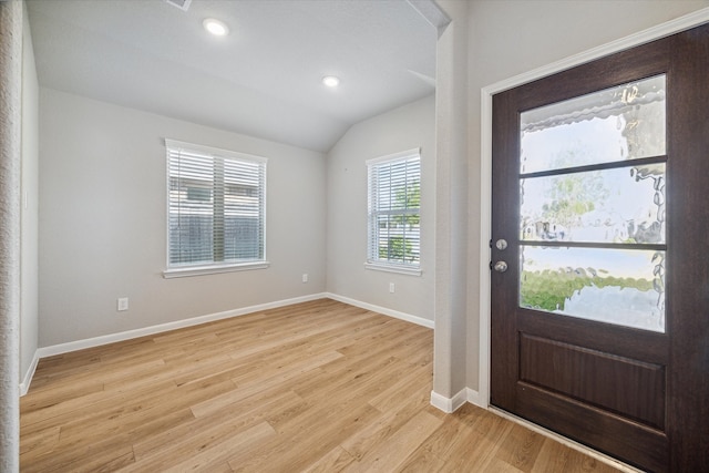 entrance foyer with lofted ceiling and light hardwood / wood-style floors