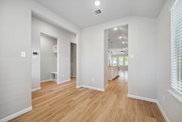 empty room with light hardwood / wood-style flooring, sink, and ceiling fan