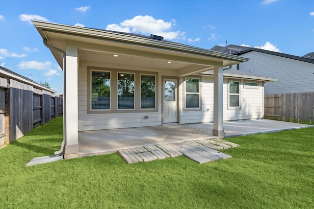 back of house with a patio and a yard