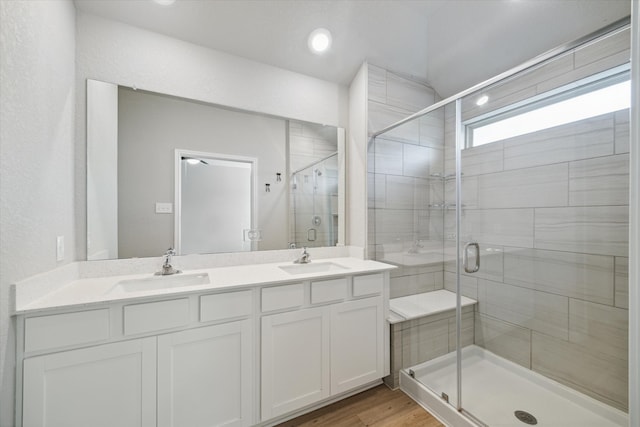 bathroom with vanity, a shower with door, and hardwood / wood-style floors