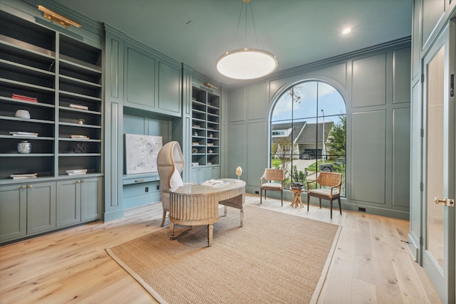 sitting room featuring built in features and light hardwood / wood-style flooring