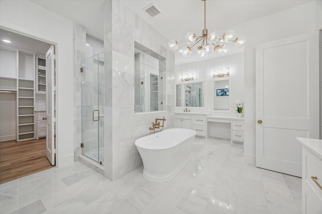 bathroom featuring vanity, separate shower and tub, and an inviting chandelier