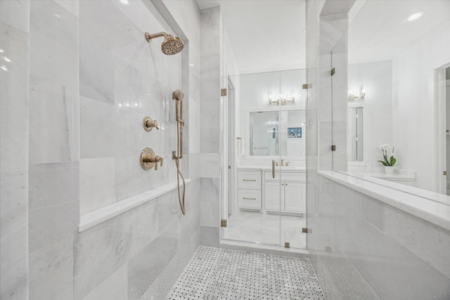 bathroom with a shower with door and vanity