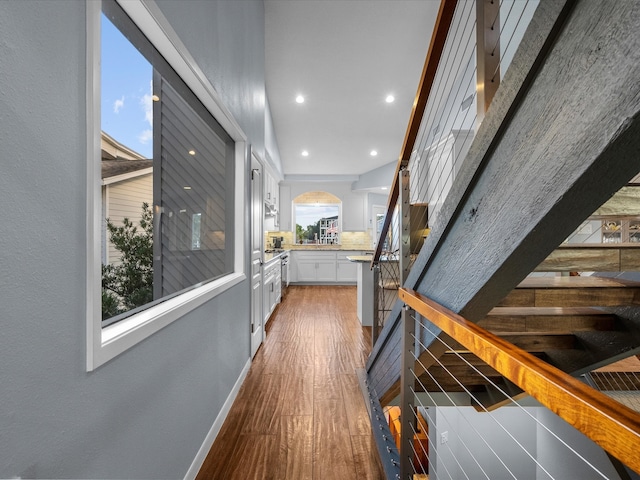 hall with dark wood-type flooring and beam ceiling