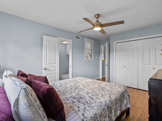 bedroom featuring a closet, ceiling fan, light hardwood / wood-style floors, and ensuite bath