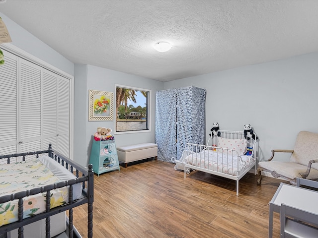 bedroom featuring a closet, wood-type flooring, and a textured ceiling