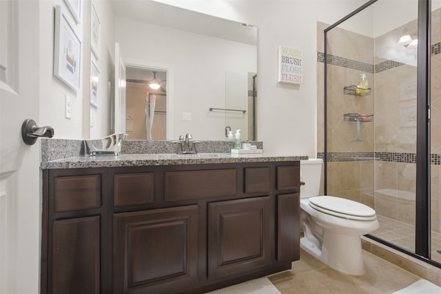 bathroom featuring vanity, tile patterned flooring, toilet, and walk in shower