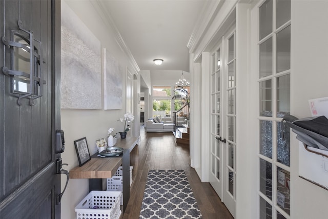 interior space with french doors, crown molding, an inviting chandelier, and dark hardwood / wood-style flooring