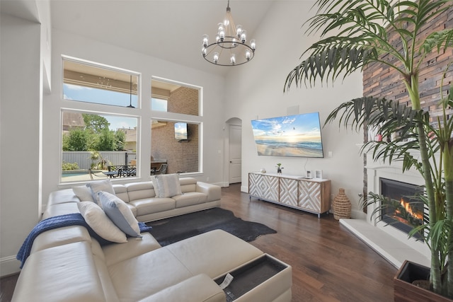 living room with dark wood-type flooring, a high ceiling, and an inviting chandelier