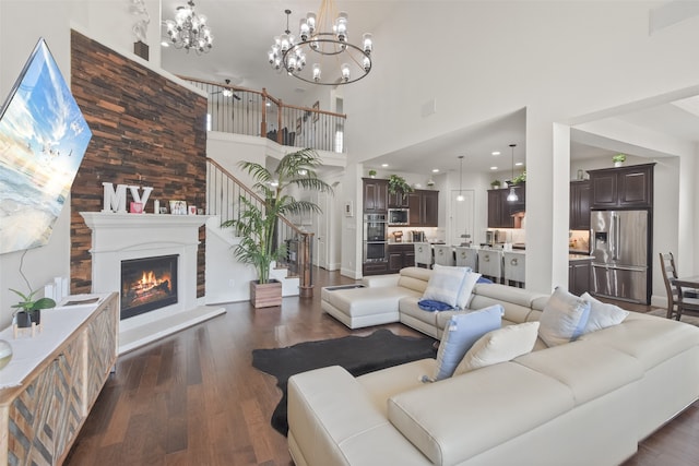 living room with a high ceiling, a chandelier, and dark hardwood / wood-style flooring