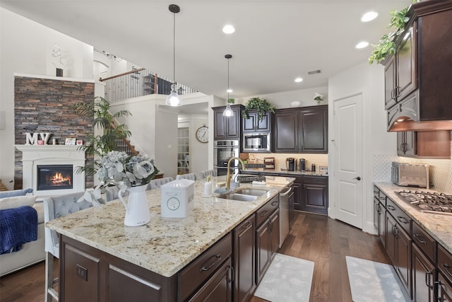 kitchen featuring dark brown cabinets, a kitchen island with sink, dark hardwood / wood-style floors, sink, and stainless steel appliances