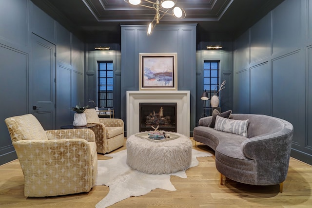 sitting room with ornamental molding and light hardwood / wood-style flooring